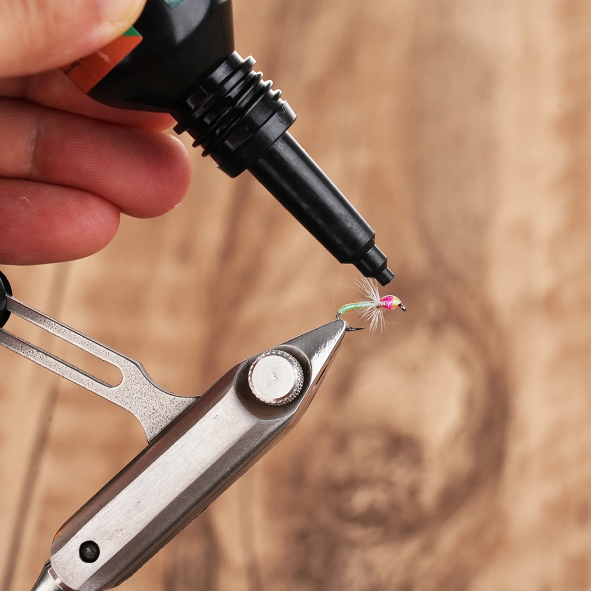 Applying WIFREO UV Clear Fly Finish to a fly held in tying pliers